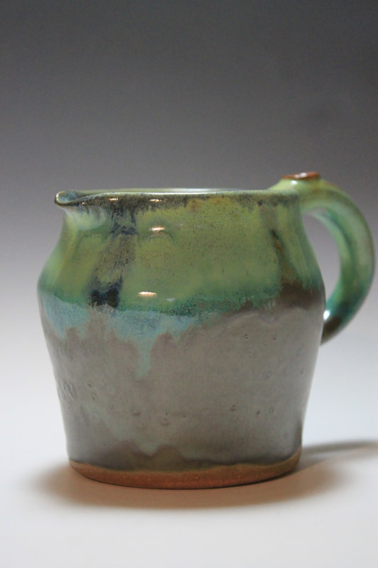 Ceramic pitcher in shades of green